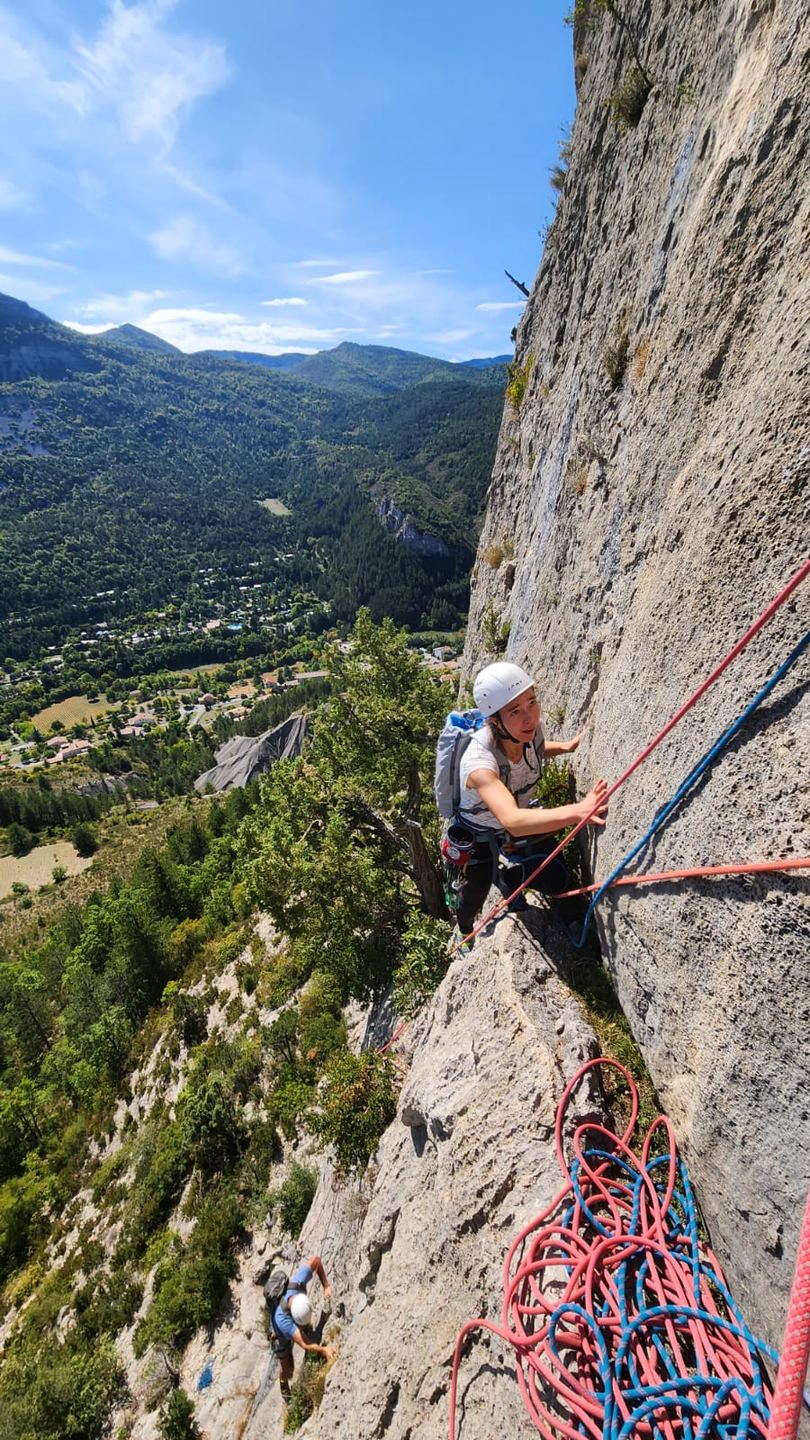 Un grimpeur au relais face au paysage d’Orpierre