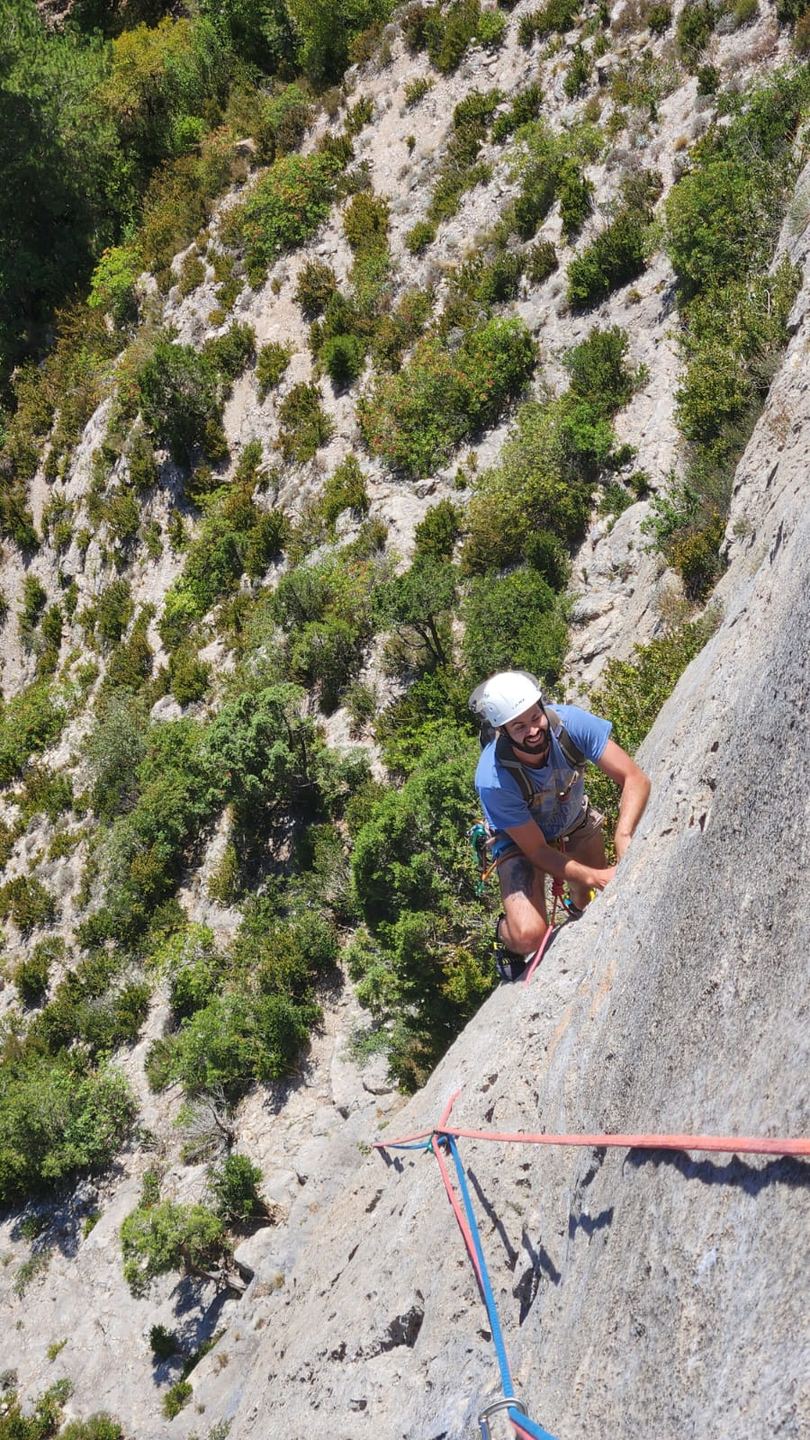 Un grimpeur progresse au-dessus du vallon à Orpierre