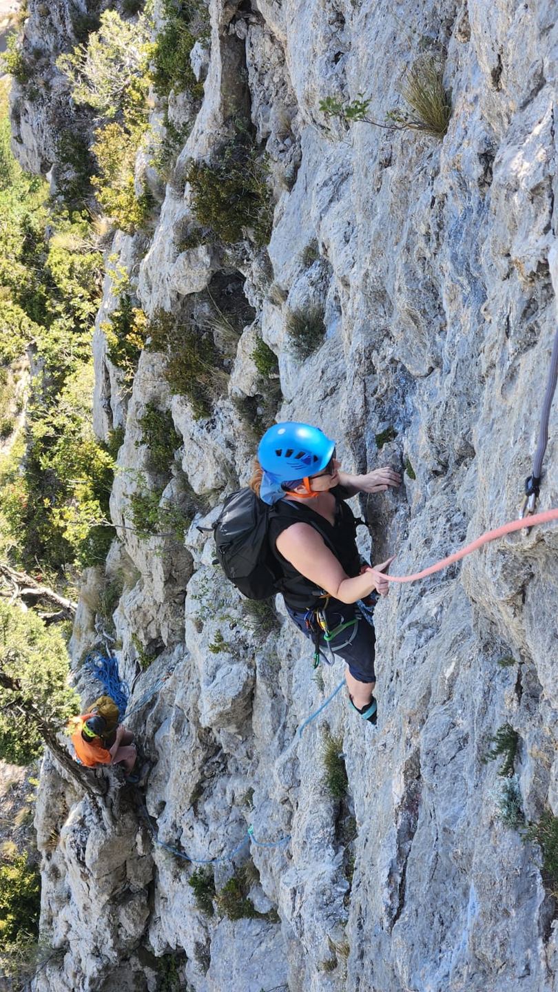 Une grimpeuse au casque bleu sur le rocher d’Orpierre